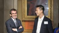 A photo of a professor casually talking with a student at a formal program retreat.